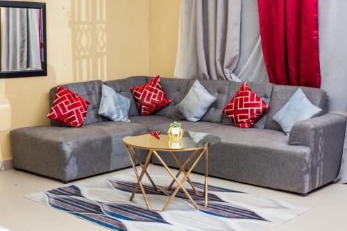 a living room with a couch with pillows and a table at Wangu Apartments in Livingstone