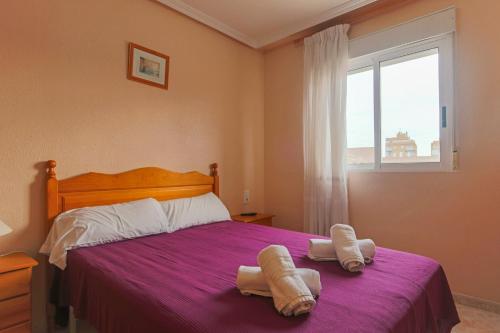 um quarto com uma cama com duas toalhas em 007 - Las Marismas 001 - comfortHOLIDAYS em Santa Pola