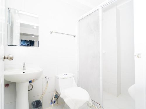 a white bathroom with a sink and a shower at CJS Boracay Joint in Boracay