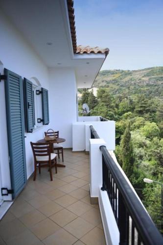 a balcony of a house with a table and chairs at Loukas Apartments in Karavostamo