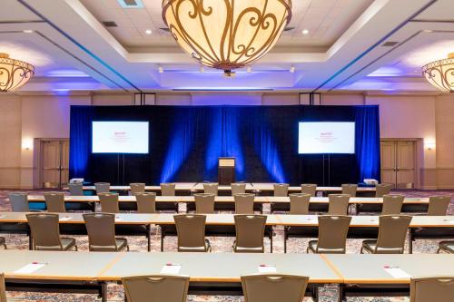 a conference room with tables and chairs and two screens at Auburn Marriott Opelika Resort & Spa at Grand National in Opelika