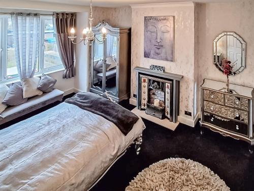 a bedroom with a large bed and a fireplace at The Garden House in Folkestone