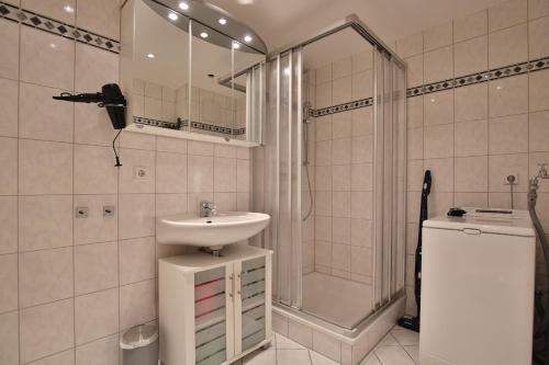 ein weißes Bad mit einem Waschbecken und einer Dusche in der Unterkunft Bädervilla Bergstraße 30 Bädervilla Bergstraße Appartement 2 in Timmendorfer Strand