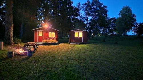 una pequeña cabaña en un campo con una mesa y una chimenea en Jõeallika kämping, 