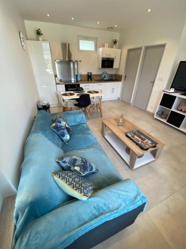 a living room with a blue couch and a table at La maison d’Alice in Aix-les-Bains