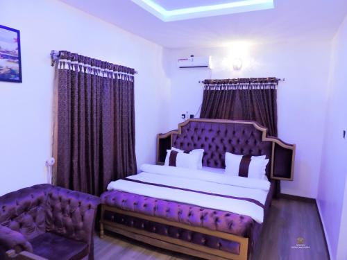 um quarto com uma cama grande e um sofá em MOSANG HOTELS & SUITES em Aba