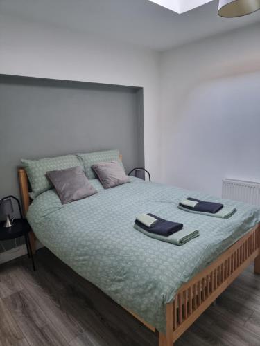uma cama num quarto com duas almofadas em Spacious Curragh 2-bed apartment with own entrance em Brownstown Cross Roads