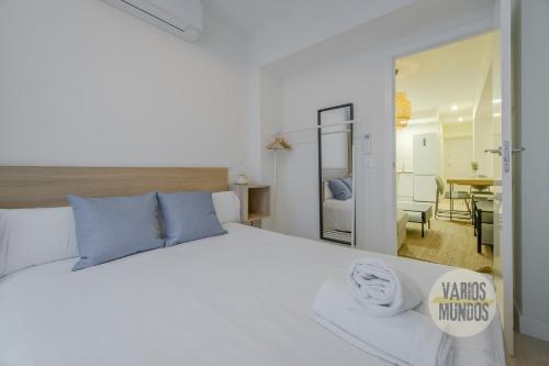 a bedroom with a large white bed with blue pillows at Cool Apt para 9pax en plena Plaza de Chueca in Madrid