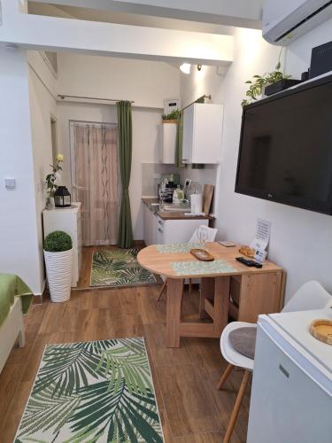 a living room with a table and a kitchen at Várfal apartman II in Eger