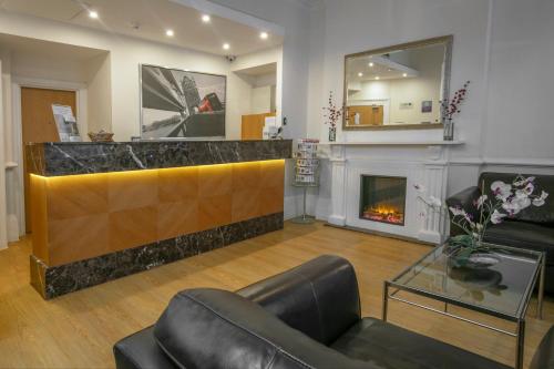 ein Wohnzimmer mit einem Sofa und einem Kamin in der Unterkunft Queensway Hotel, Sure Hotel Collection by Best Western in London