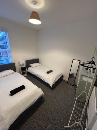 利物浦的住宿－Charming Liverpool Home，客房设有两张床、梯子和镜子