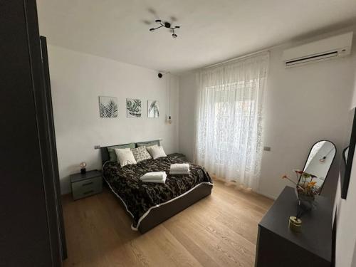 sypialnia z łóżkiem i dużym oknem w obiekcie Casa vento marino w mieście Livorno