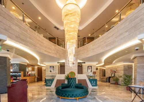 um lobby com um grande lustre no meio em Al Salam Hotel em Kuwait