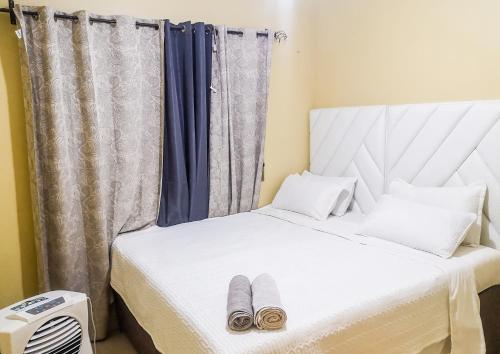 1 dormitorio con 1 cama con 2 zapatillas en Wanita Apartments en Livingstone