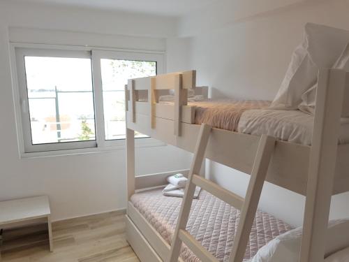 a bedroom with a bunk bed and a window at Panorama House* in Kavala