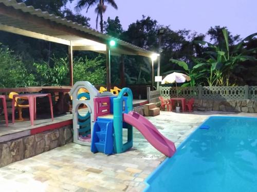 uma piscina infantil com escorrega e um parque infantil em Pousada Recanto do Zeca casa 3 na Praia Grande