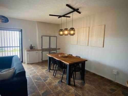 uma sala de estar com uma mesa e um sofá em Beachfront 3 bedroom house em Hentiesbaai