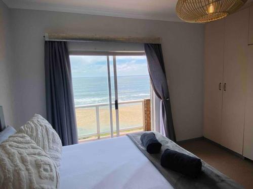 ハンティスバイにあるBeachfront 3 bedroom houseのビーチの景色を望むベッドルーム1室(ベッド1台付)