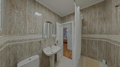 ein Bad mit einem Waschbecken und einem Spiegel in der Unterkunft Casa Angela in Santoña