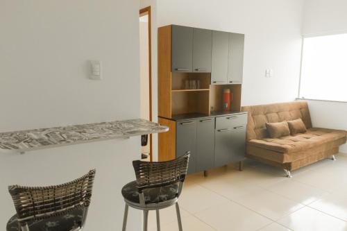 a kitchen with a couch and a table and chairs at Residencial Sales in Guaibim