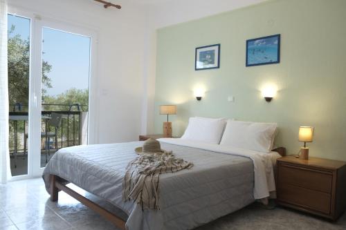 a bedroom with a bed and a large window at Aphrodite Studios in Kallithea Halkidikis