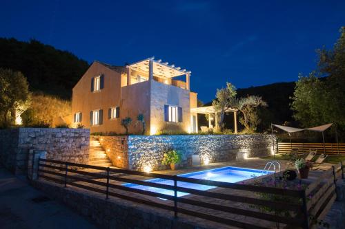 une villa avec une piscine la nuit dans l'établissement Villa Authentica Lopud, Dubrovnik, à Lopud