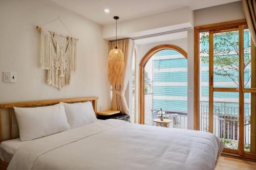 een slaapkamer met een bed en een groot raam bij Le Petit Homestay 2 in Hue