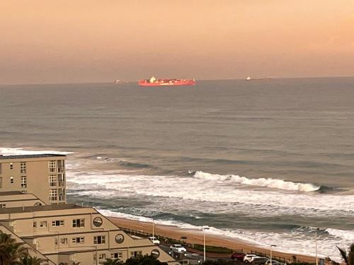 a large container ship in the ocean near the beach at Umdloti Holiday Resort Apartment 514 - Amazing Breaker & Ocean Views in Umdloti