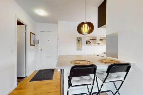 Nordic style apartment in central Aalborg في ألبورغ: مطبخ مع جزيرة مع كرسيين