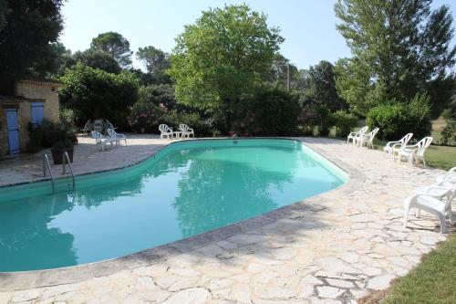 une grande piscine avec des chaises et une table dans l'établissement Les Messugues typical Provencal farmhouse with shared pool nature peace, à Flayosc