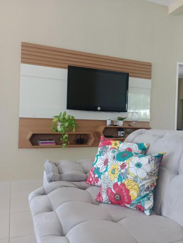 salon z białą kanapą i telewizorem na ścianie w obiekcie Casa Raios de Sol w mieście São Raimundo Nonato