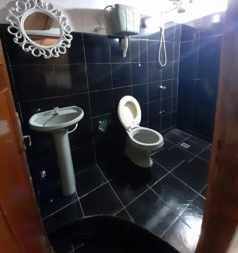 a bathroom with a toilet and a sink and a mirror at Apartamento Monoambiente a 15 min del Aeropuerto zona Shopping Mariano in Colonia Mariano Roque Alonso