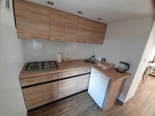 a kitchen with wooden cabinets and a sink and a stove at Apartament Mickiewicza in Stronie Śląskie