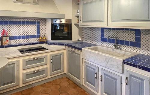 uma cozinha com armários brancos e azulejos azuis em Shaleo, Casa indipendente con piscina privata, Marliana em Marliana