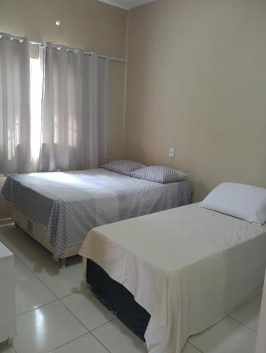 dwa łóżka siedzące obok siebie w sypialni w obiekcie Casa Raios de Sol w mieście São Raimundo Nonato