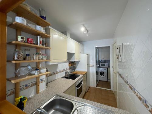 eine kleine Küche mit Spüle und Kühlschrank in der Unterkunft Cozy apartment in Costa del Sol in Mijas Costa
