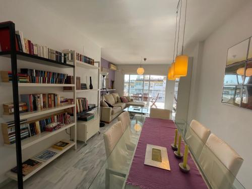 ein Wohnzimmer mit einem Glastisch und einem Bücherregal in der Unterkunft Cozy apartment in Costa del Sol in Mijas Costa