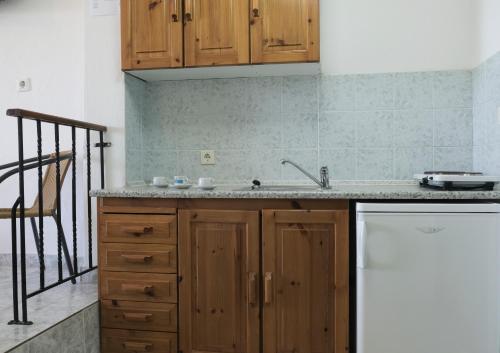 a kitchen with wooden cabinets and a white refrigerator at Aphrodite Studios in Kallithea Halkidikis