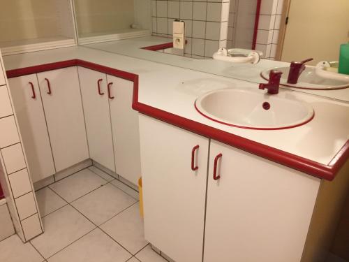 La salle de bains blanche est pourvue d'un lavabo et d'un miroir. dans l'établissement jerome, à Nivezé