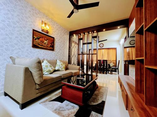 a living room with a couch and a table at Chic 2BR Haven in the midst of greenery. in Mangalore