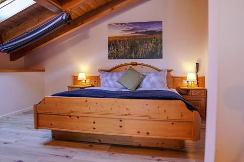 sypialnia z drewnianym łóżkiem i 2 szafkami nocnymi w obiekcie HoFer am Zeitberg Ferienwohnung Kindelsbach w mieście Bad Kohlgrub