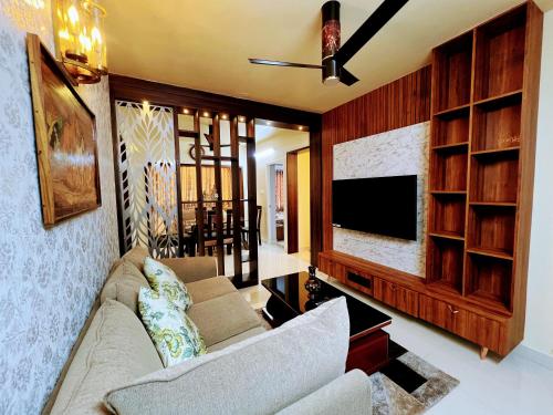 a living room with a couch and a tv at Chic 2BR Haven in the midst of greenery. in Mangalore