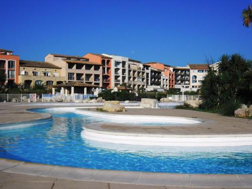 - une piscine dans un complexe avec des bâtiments en arrière-plan dans l'établissement GASMIC - Appartement pour 4 personnes avec piscine et accès direct à la plage situé aux marines de Gassin, à Gassin