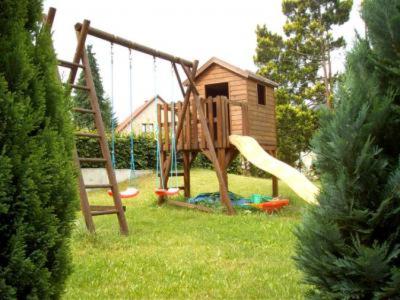 un parque infantil con un tobogán en un patio en Ferienwohnung - Landhotel Waldschlößchen en Sohland