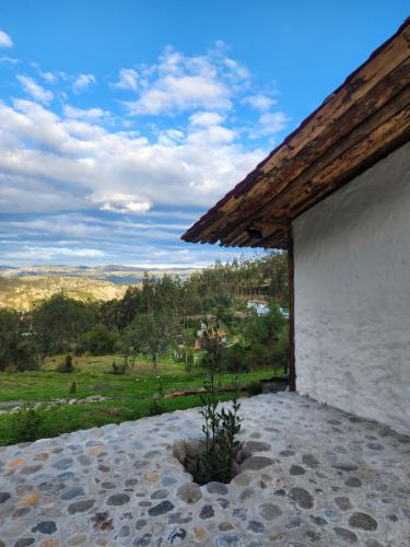 昆卡的住宿－Hermosa y Nueva Cabaña de campo - La Candelaria Farm House，享有田野景致的白色建筑