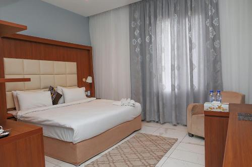 Habitación de hotel con cama y silla en San Marino Hotel en Accra