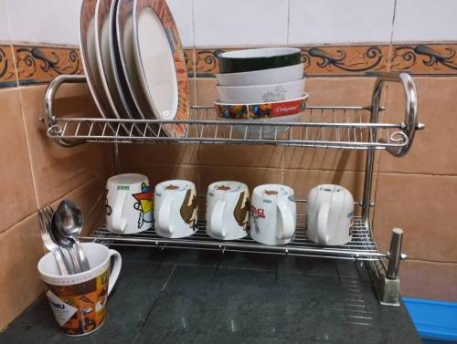 - un portant avec des assiettes, des tasses et de la vaisselle dans l'établissement Kim Kim Homestay Melaka(11 Pax 4R2B), à Malacca