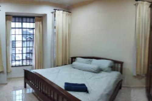 une chambre avec un grand lit avec des oreillers bleus dans l'établissement Kim Kim Homestay Melaka(11 Pax 4R2B), à Malacca