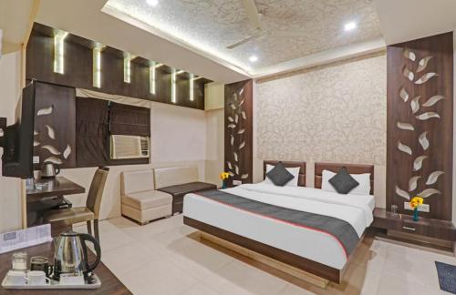 a bedroom with a bed and a desk in a room at Hotel Tirupati Galaxy in Kānpur