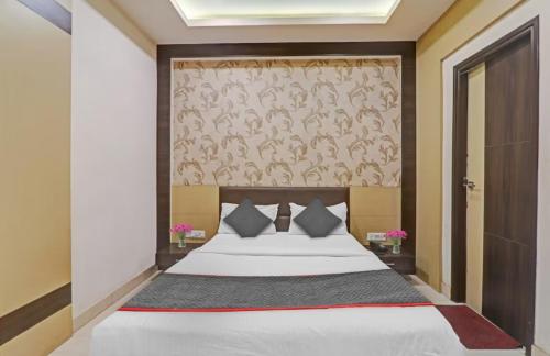 a bedroom with a large bed and a wall at Hotel Tirupati Galaxy in Kānpur